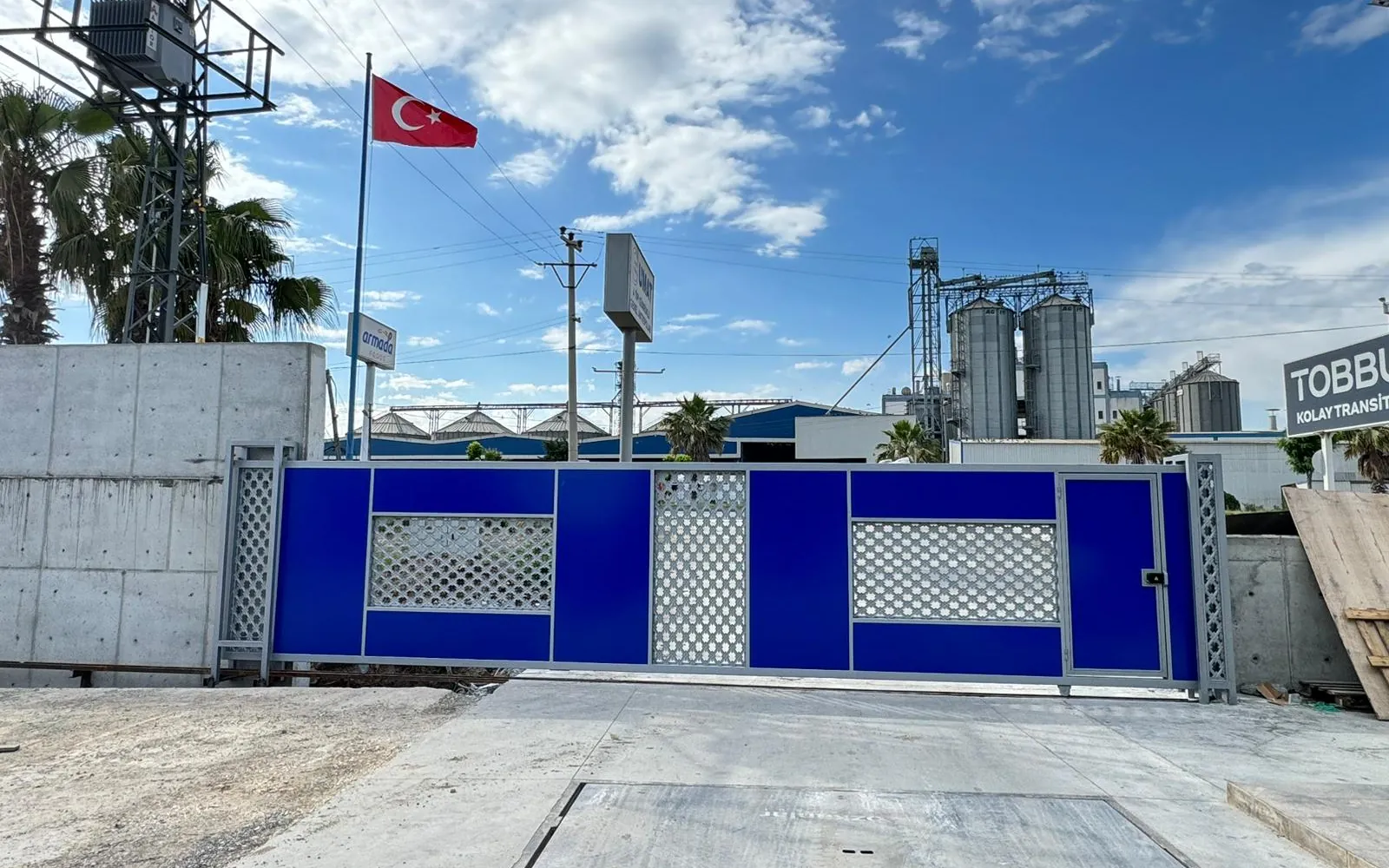 Bir fabrika girişinde mavi panelli otomatik yana kayar kapı